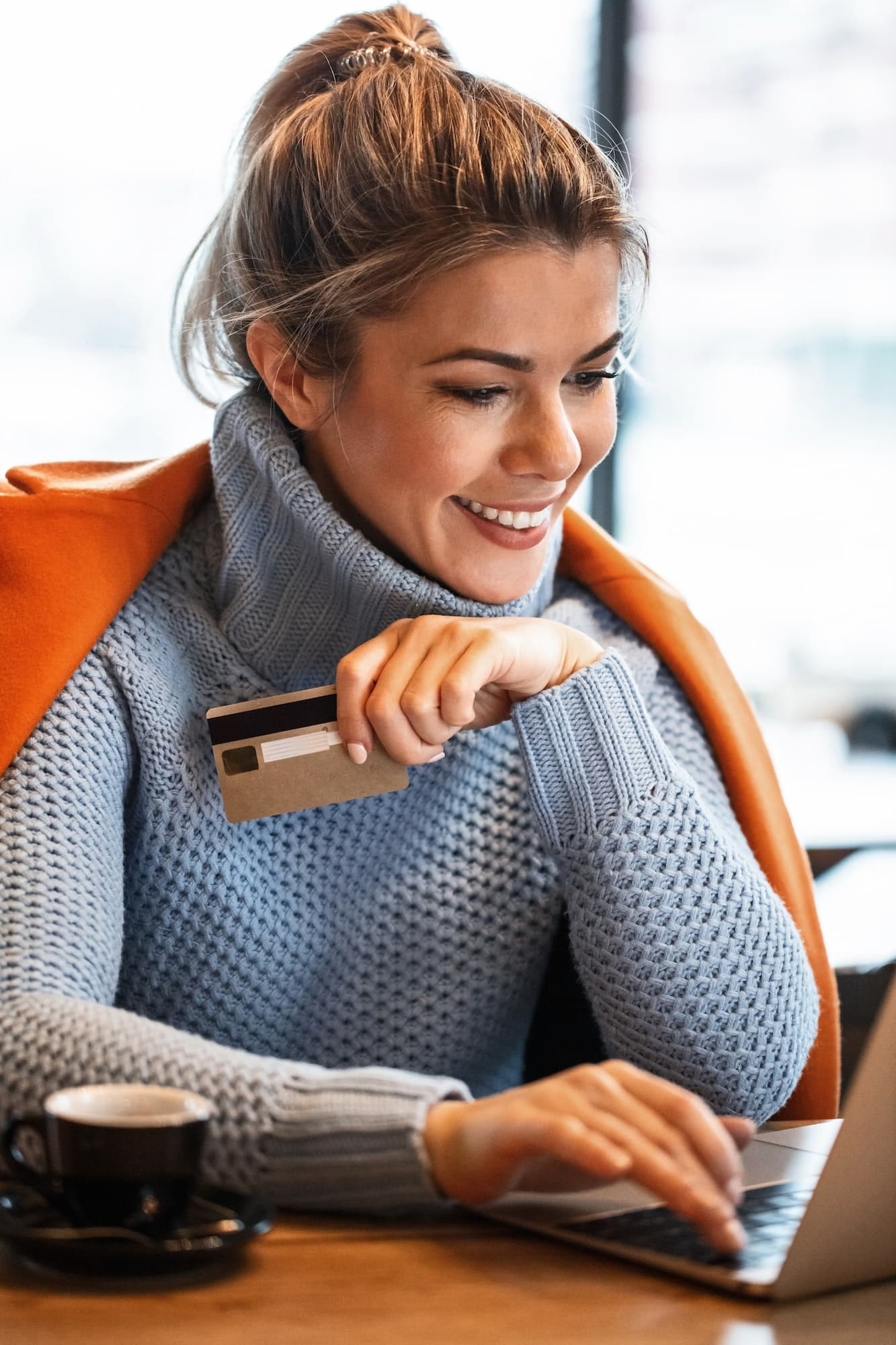 Smiling businesswoman checking her online bank account on laptop.