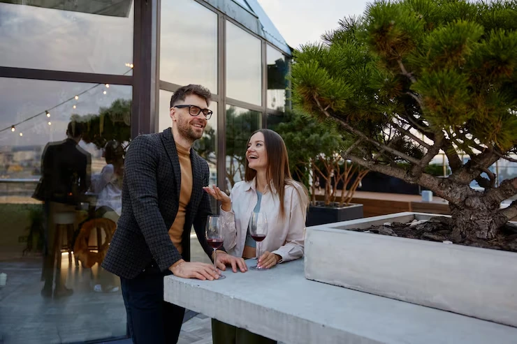 Professional couple enjoying wine at modern rooftop venue with city views and ambient lighting