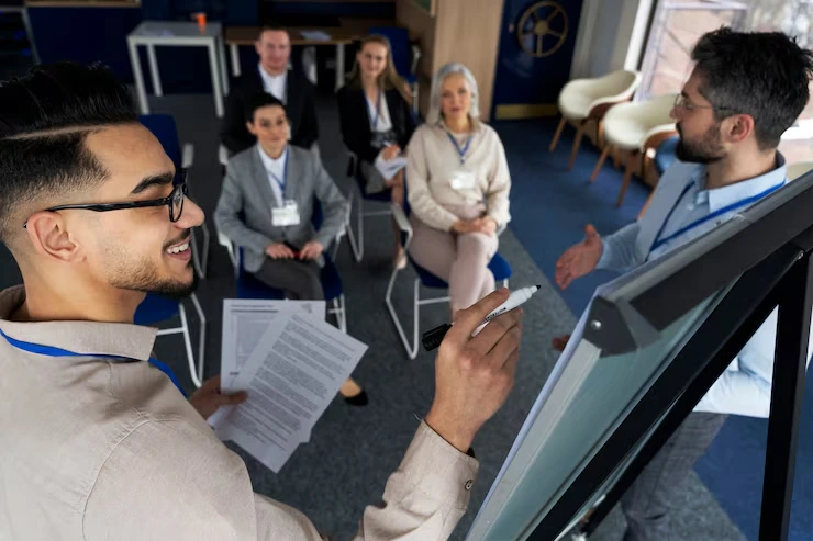 Conference facilitator engaging with attendees during interactive workshop session using flipchart presentation