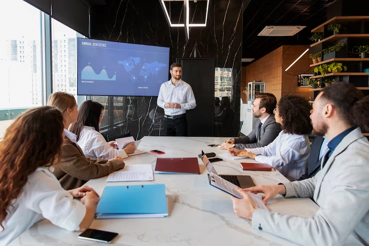 Professional presenter delivering seminar to business audience using data analytics display screen