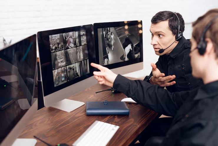 Event production team coordinating live streaming and virtual attendee management using multiple monitors