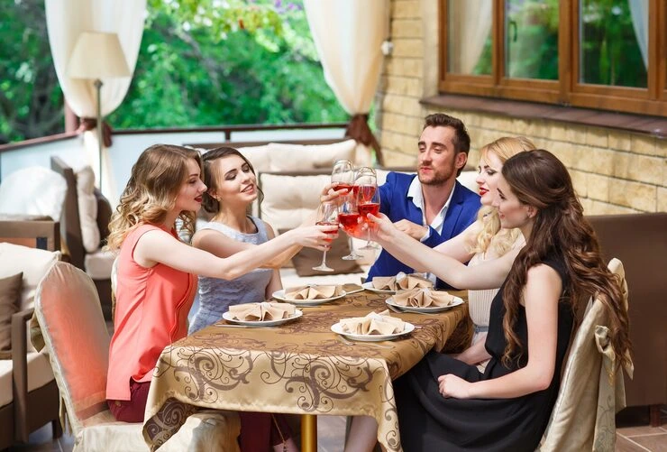 Event Management Company in Copenhagen, Denmark Group of friends toasting with wine glasses during intimate celebration on elegant outdoor terrace