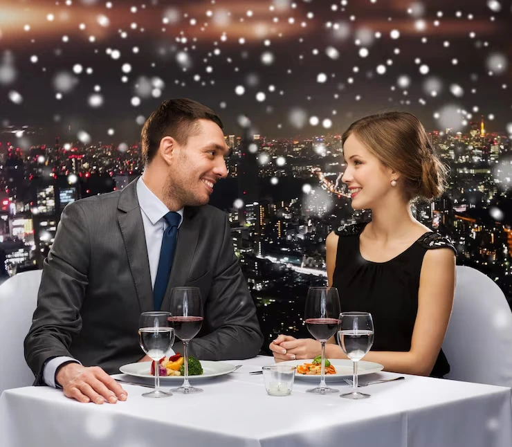 Elegant couple enjoying intimate dinner with city skyline views and sparkling ambient lighting effects
