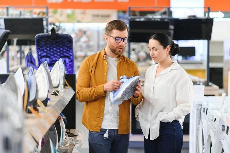Man and woman examining product samples together at modern retail display with colorful brand installations