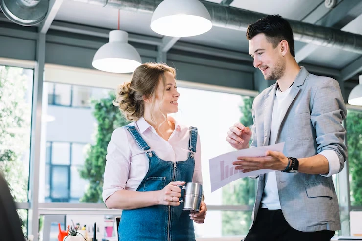 Event manager reviewing detailed planning documents with chef in modern industrial kitchen workspace