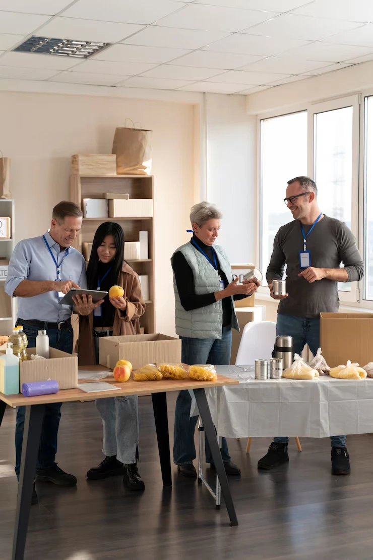 Event Management Company in Budapest, Hungary for Corporate and Private Events Volunteers organizing food and supplies during corporate charity event in bright office space