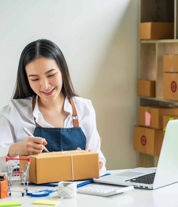 Asian small business owner holds a pen to write down addresses to deliver parcels to customer, Brand Sampling Agency London, Experiential Marketing Agency, Creative Marketing Agency For Technology Companies in London