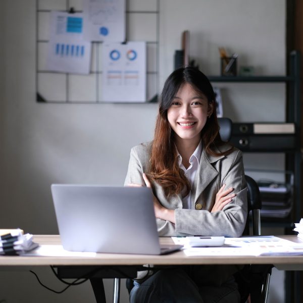 business Asian woman working online at home office and looking at the camera.