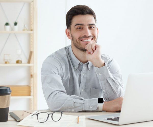 Business guy looking at camera with positive smile, ready to help and answer questions