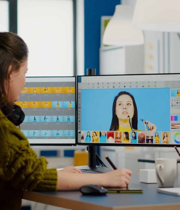 Female photographer edits photos in creative media agency office