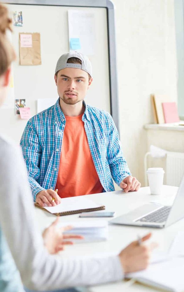 Handsome guy discussing university project with group mate, Influencer Marketing Agency