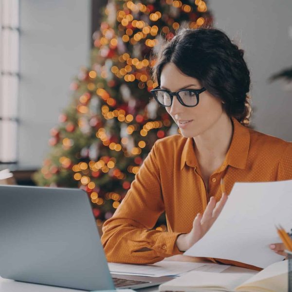 Hispanic business lady in glasses working online in office on Christma,