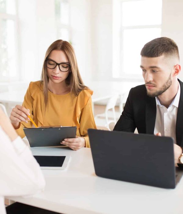 Pensive business man with laptop and business woman in eyeglasses,