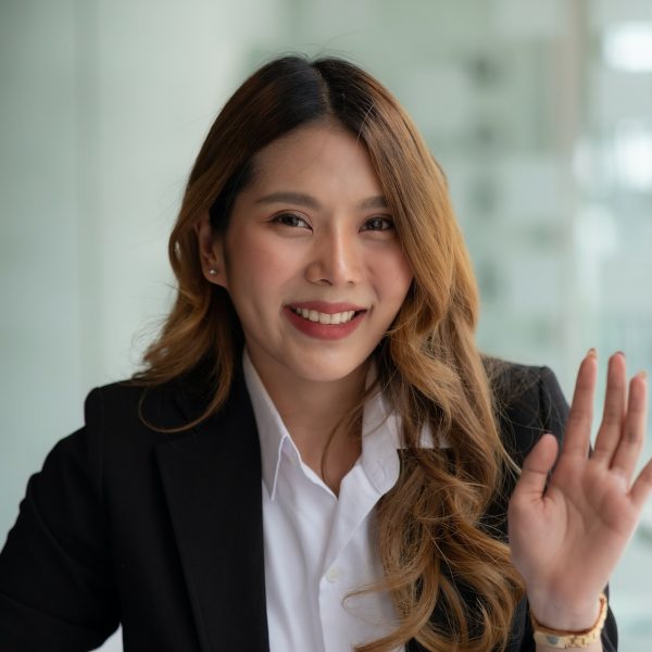 Smiling business asian woman face waving hand talking to webcam, social media influencer streaming