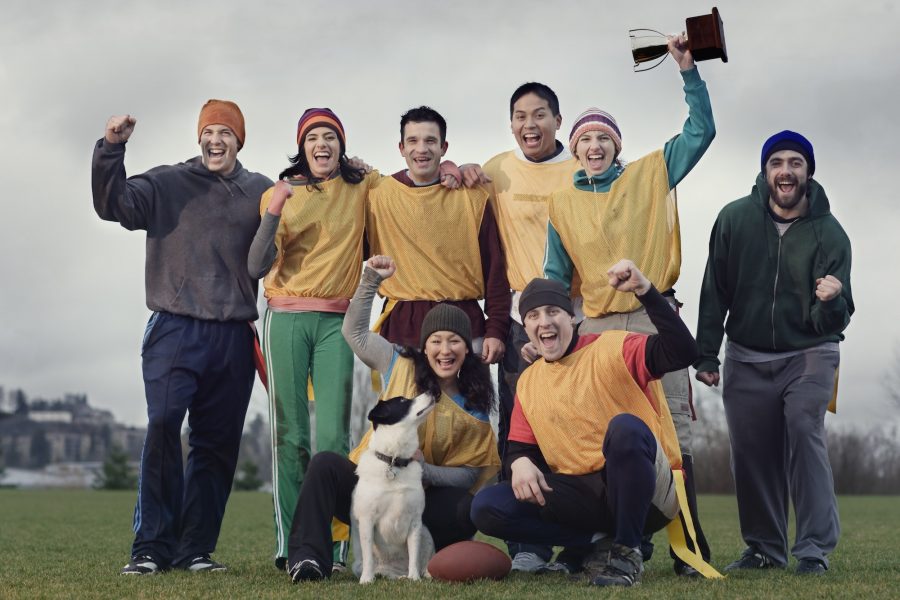 Team members celebrating a victory and a trophy in an outdoor sporting event in the winter.
