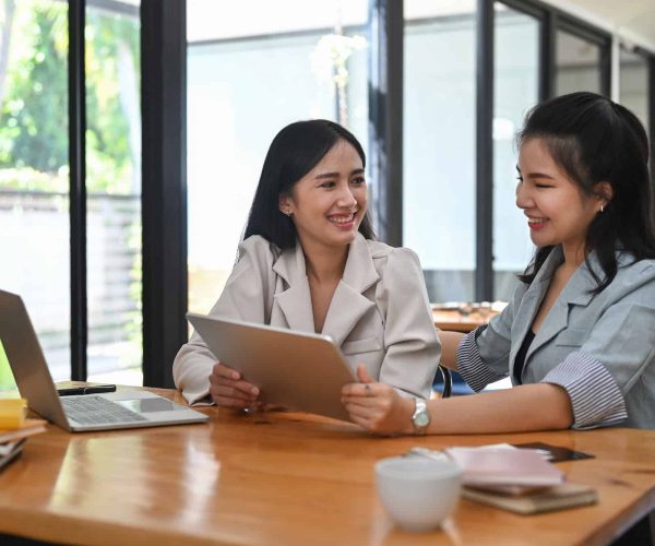 Two business women sharing ideas or startup business plan together.