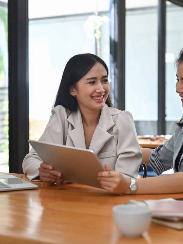 Two business women sharing ideas or startup business plan together.