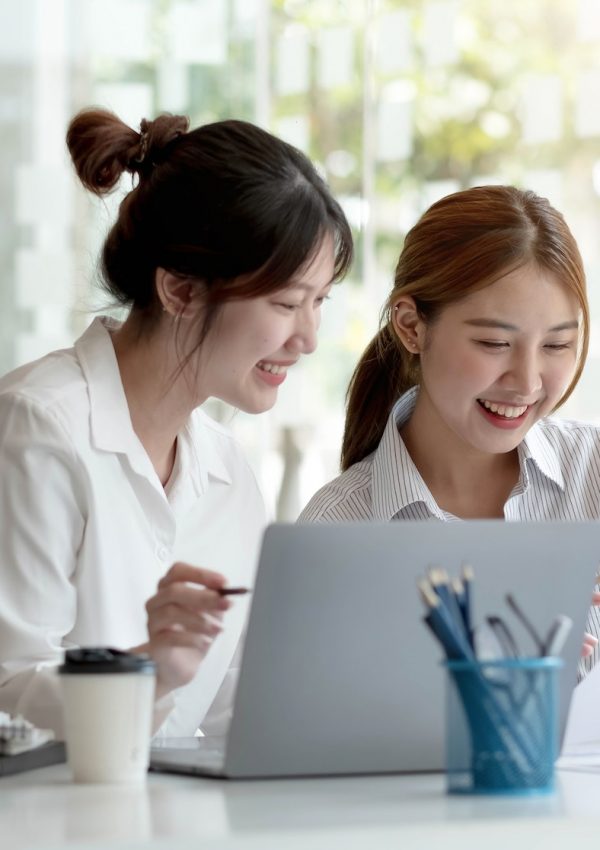Two young Asian businesswoman discuss investment project working and planning strategy. Business
